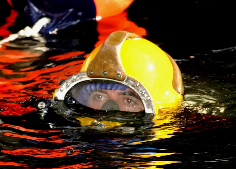 Penyelam Angkatan Laut AS mengenakan helm selam laut-dalam MK-21, bersiap turun untuk pekerjaan konstruksi bawah laut